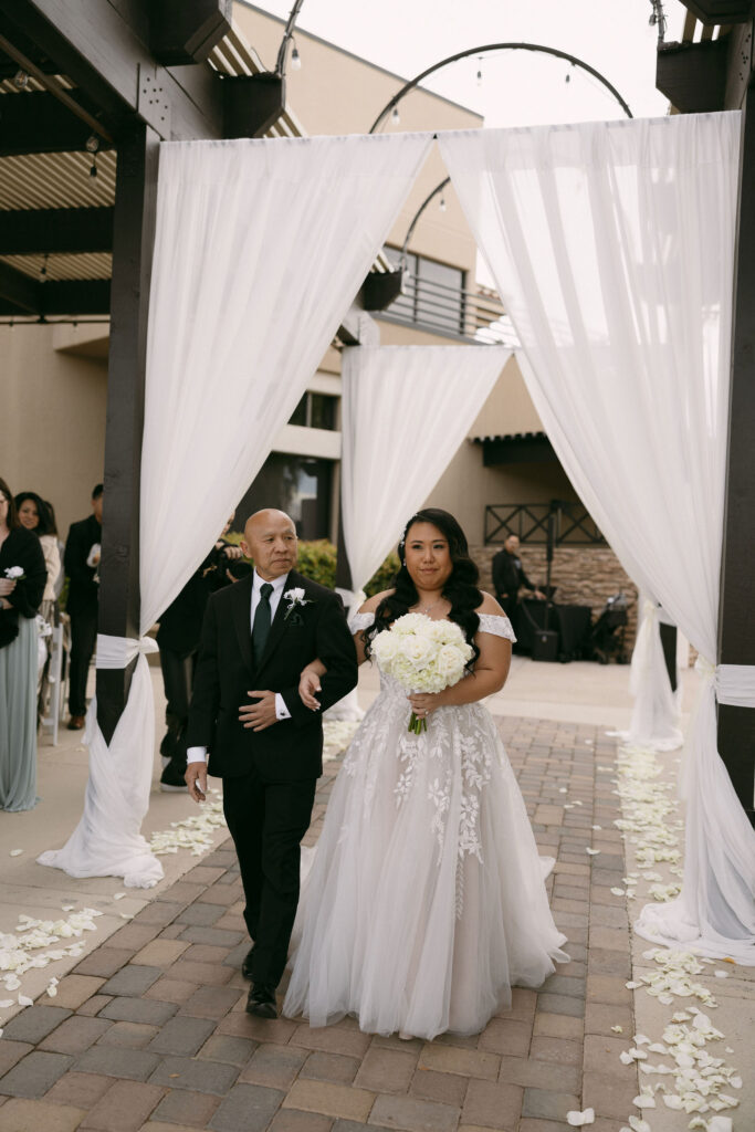 Bride being walked down the aisle by her father