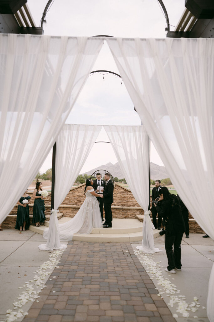 Bride and groom holding hands during their Stallion Mountain wedding ceremony on The Patio