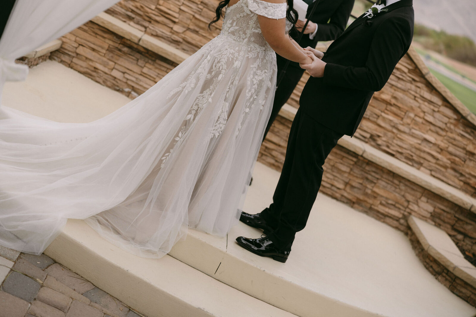 Bride and groom holding hands during their Stallion Mountain wedding ceremony on The Patio