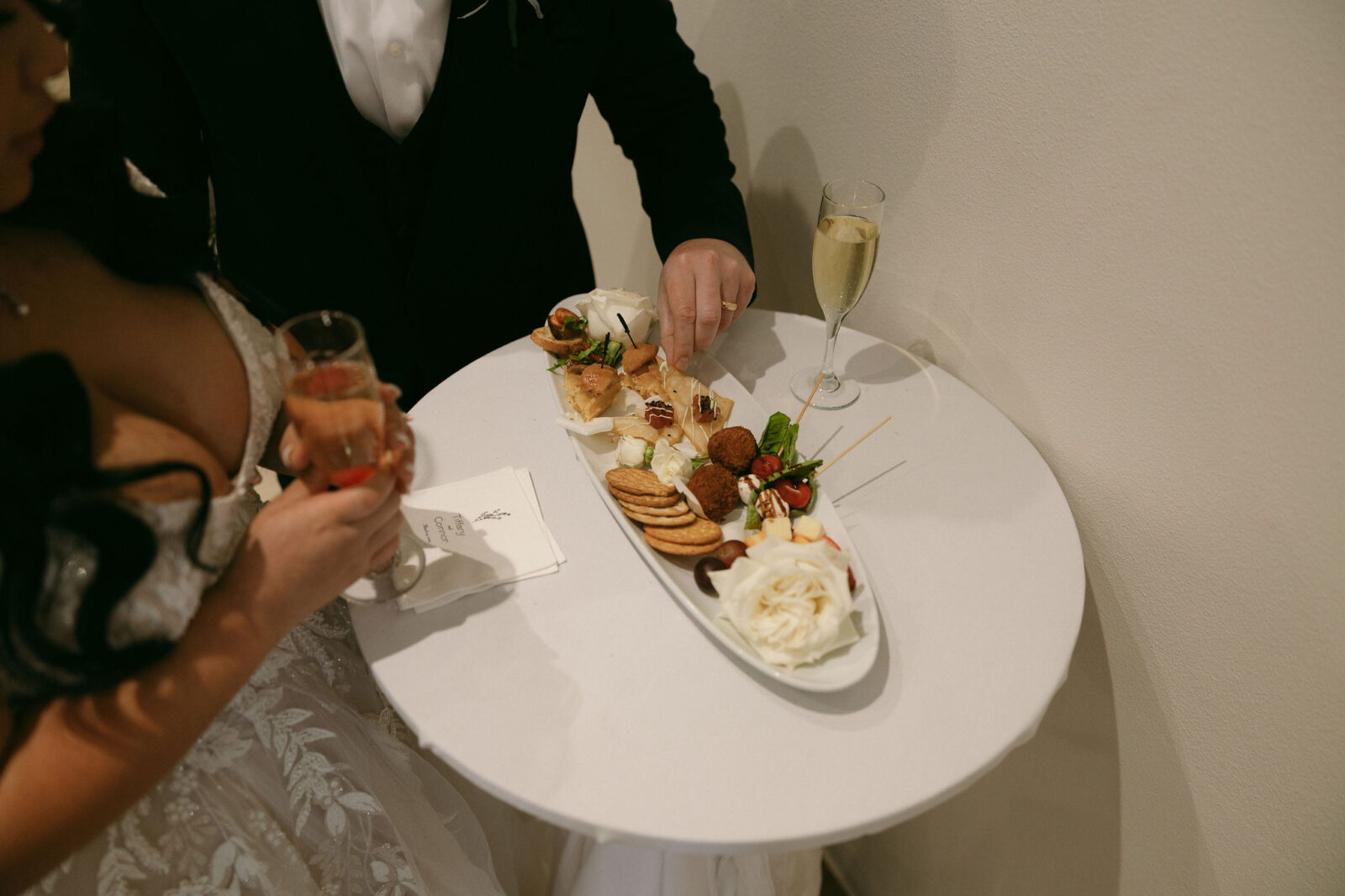 Bride and groom tasting from their personal charcuterie board