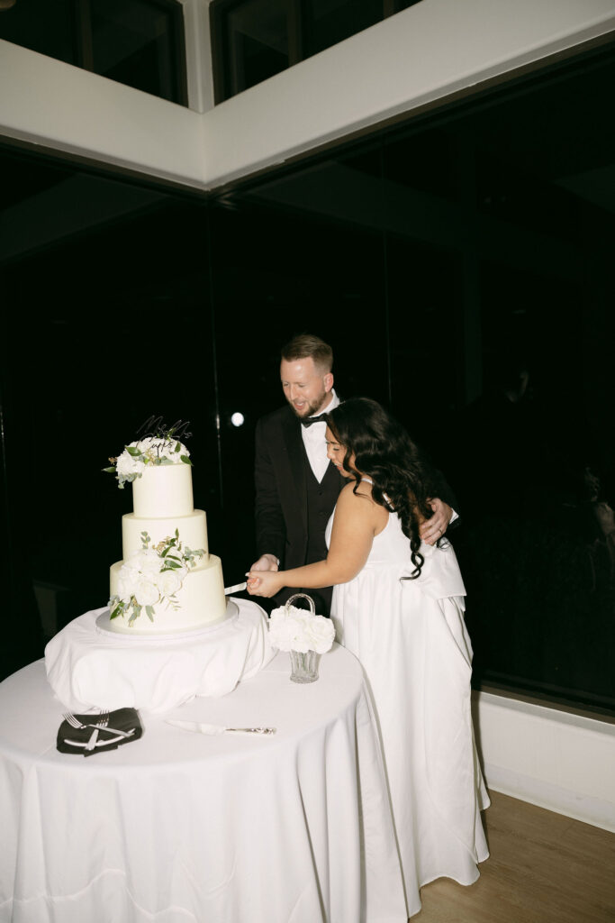 Bride and groom cutting into their wedding cake