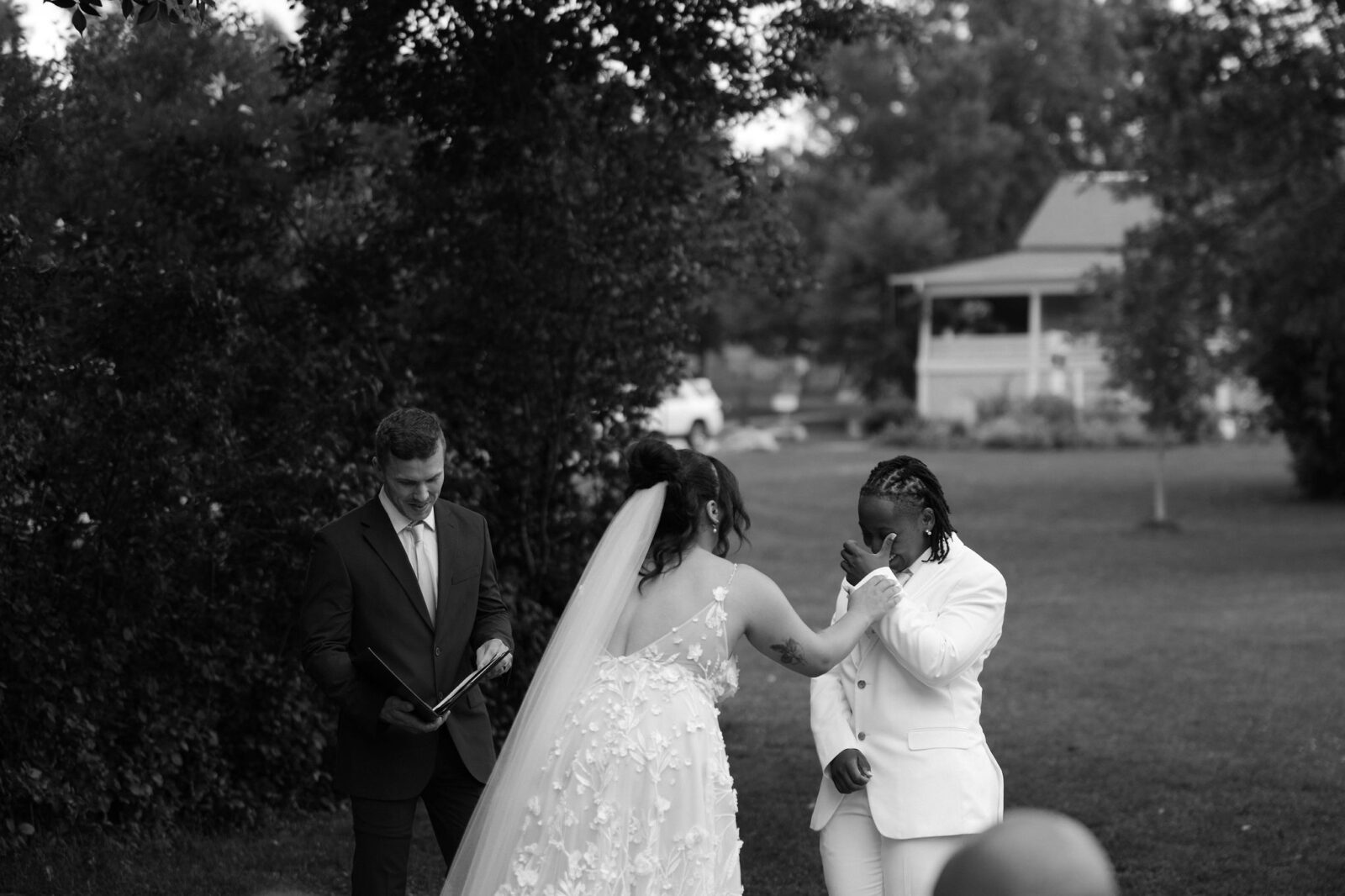 Black and white photo of a couple getting emotional during their outdoor wedding ceremony