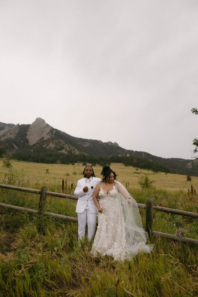 Couple posing along a rustic fence for their Chautauqua Park wedding portraits in the mountains