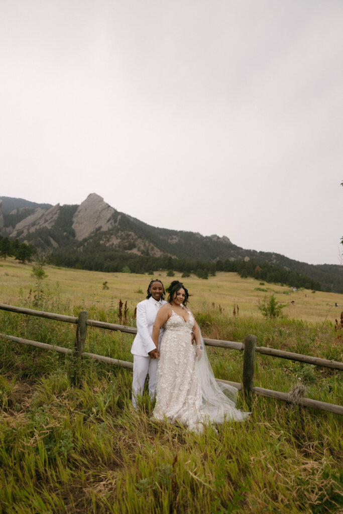 Couple posing along a rustic fence for their Chautauqua Park wedding portraits in the mountains