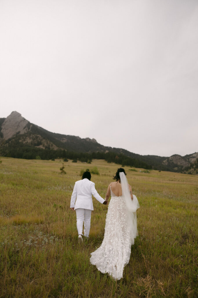 Couple walking into the mountains for their Chautauqua Park wedding portraits