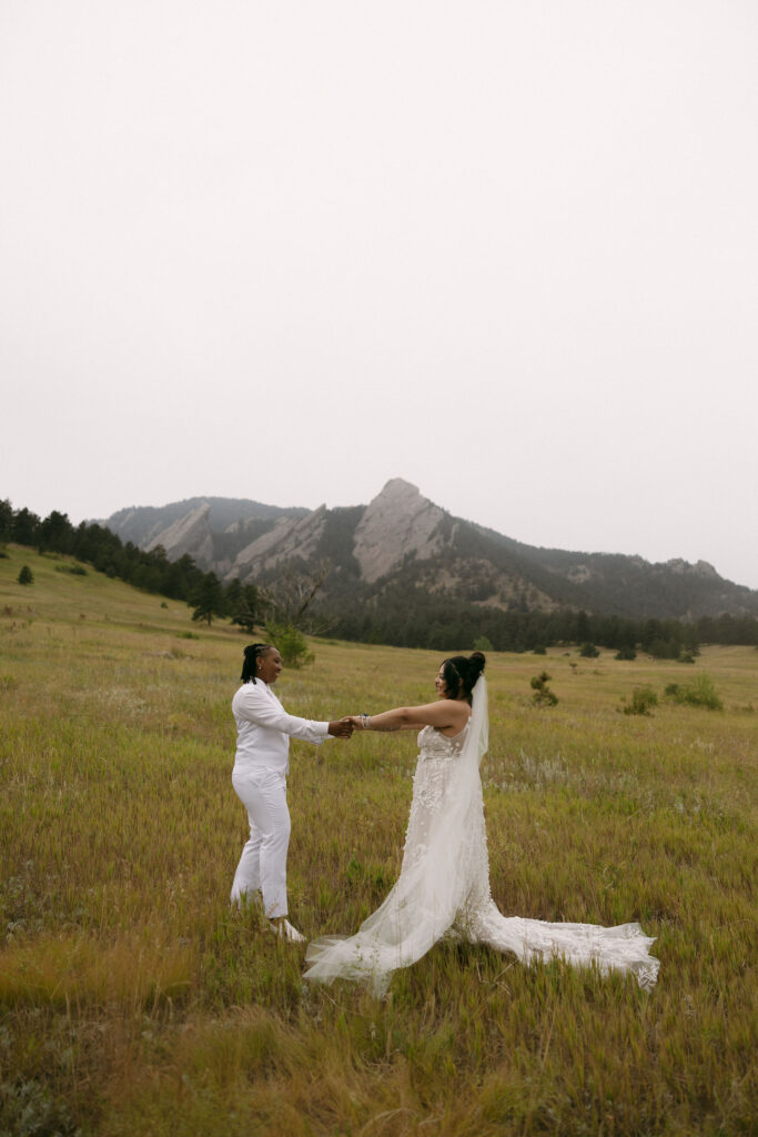 Couple holding hands in the Colorado mountains for their Chautauqua Park wedding portraits