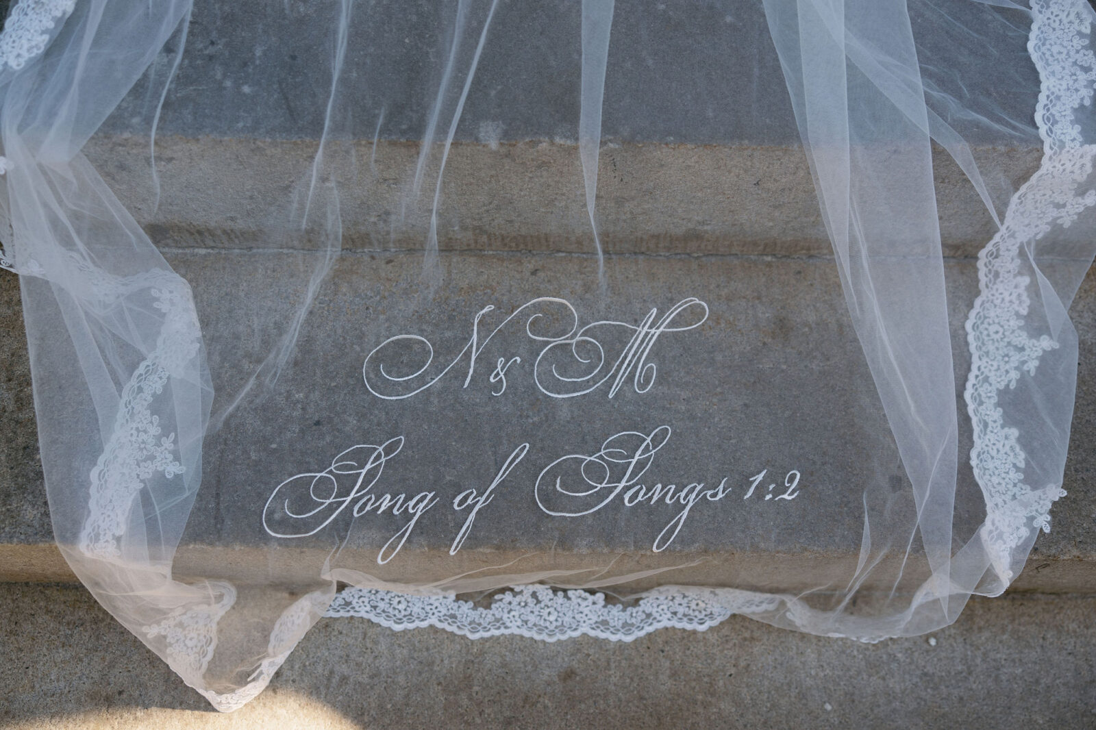 Wedding veil that says "N & M Song of Songs 1:2"
