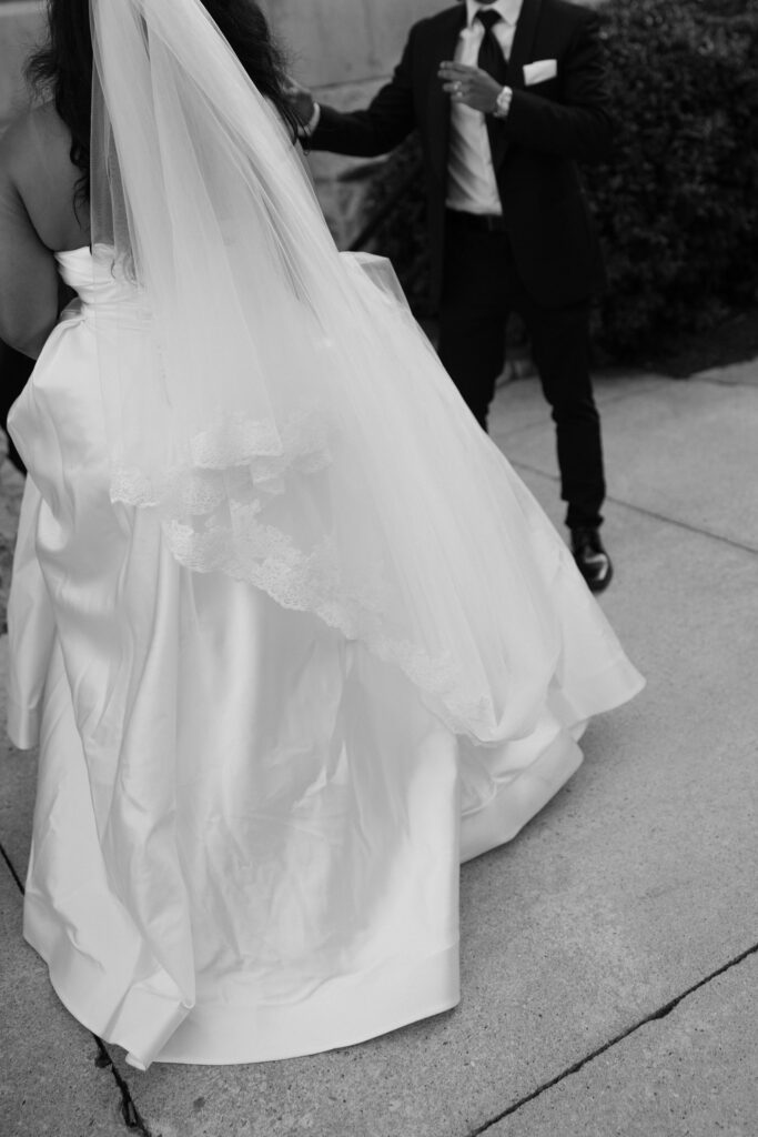 Black and white photo of a bride and groom being playful