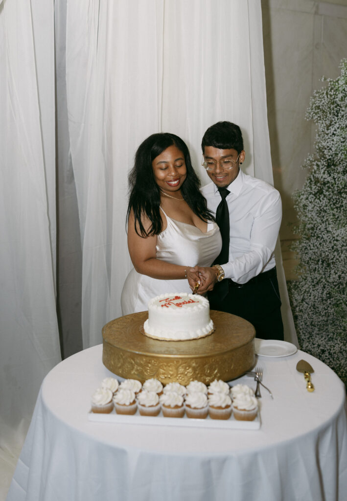 Bride and groom cutting into their cake