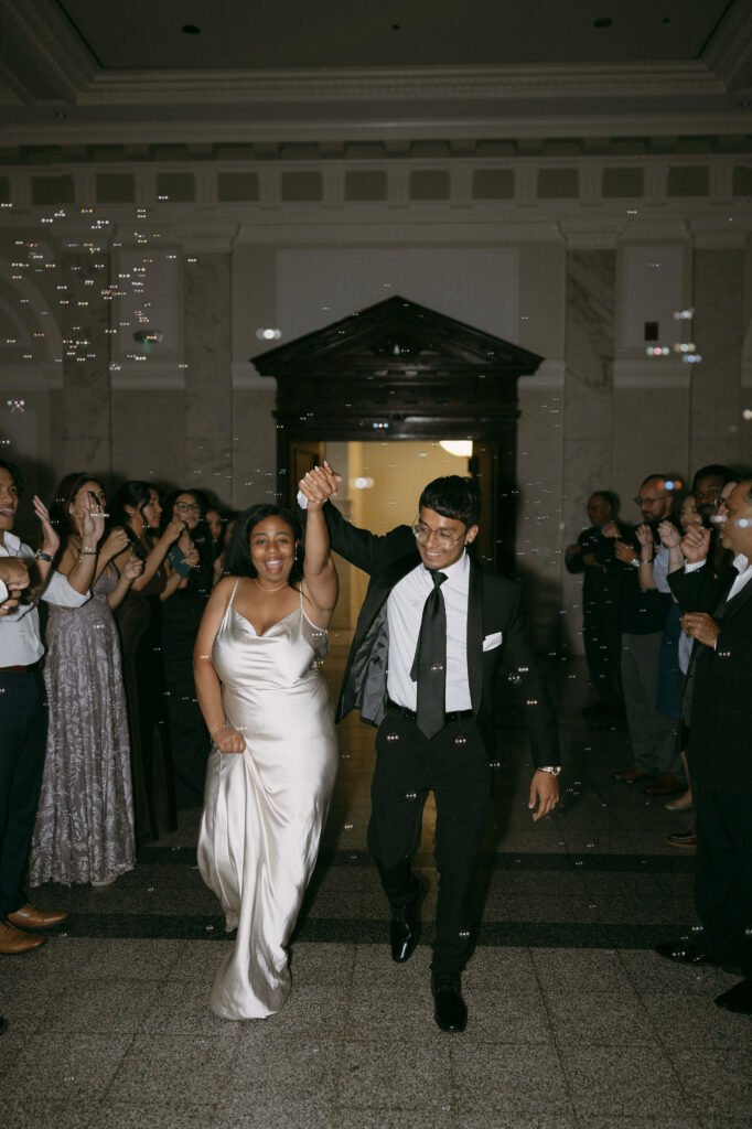 Bride and grooms bubble exit after their intimate Historic DeKalb Courthouse wedding in Atlanta, Georgia