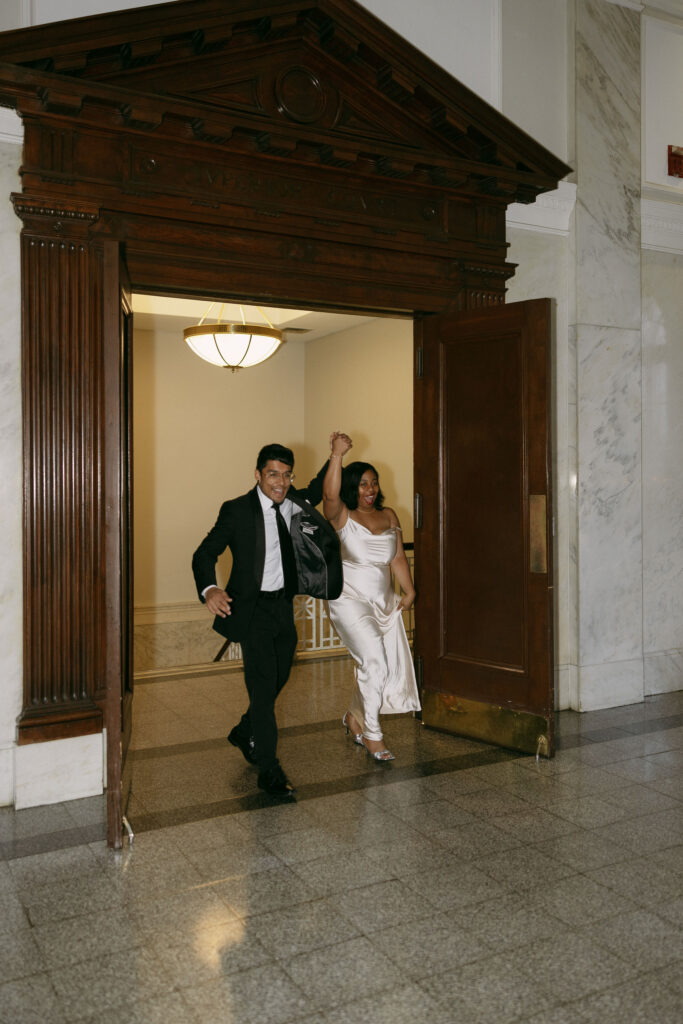 Bride and groom entering their intimate Historic DeKalb Courthouse wedding reception in Atlanta, Georgia