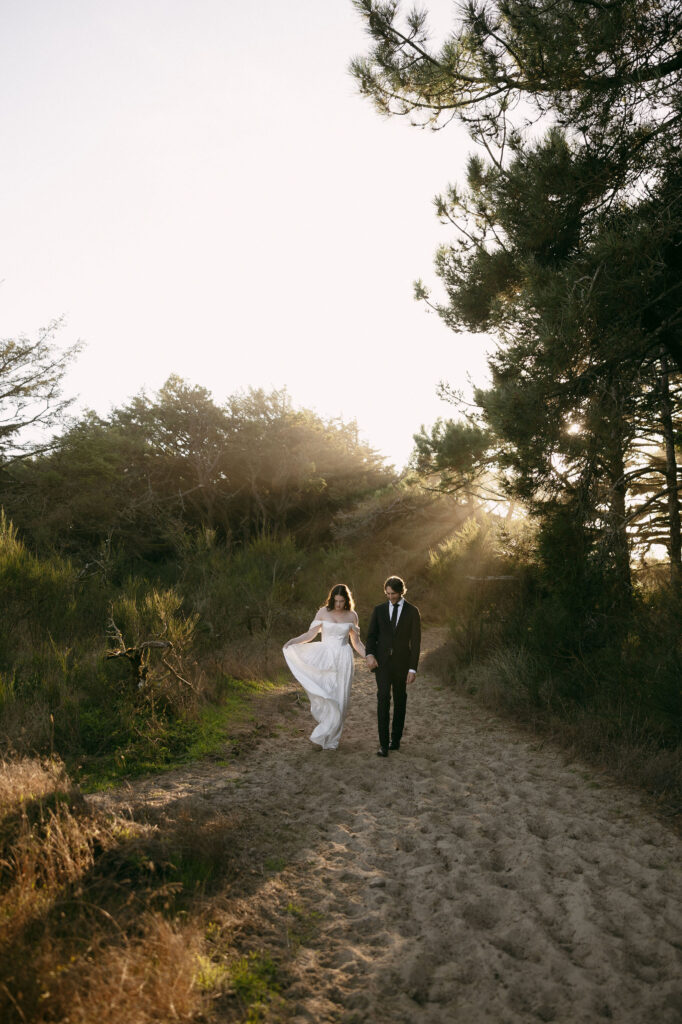 Couple walking down a sandy hill during their intimate elopement