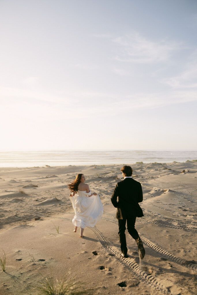 Couple running along the Northern Oregon Coast for their elopement