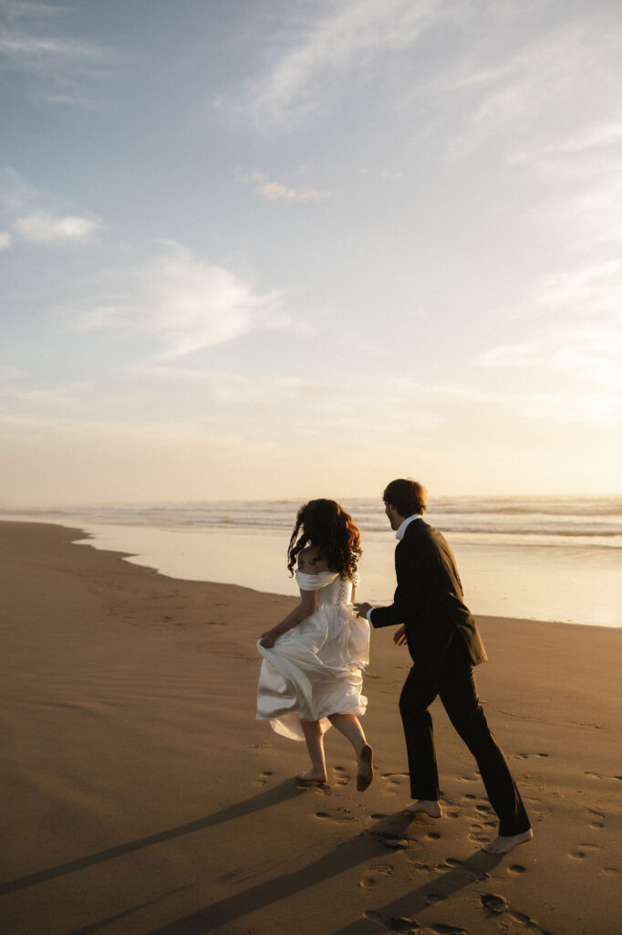 Couple running along the Northern Oregon Coast during their intimate elopement