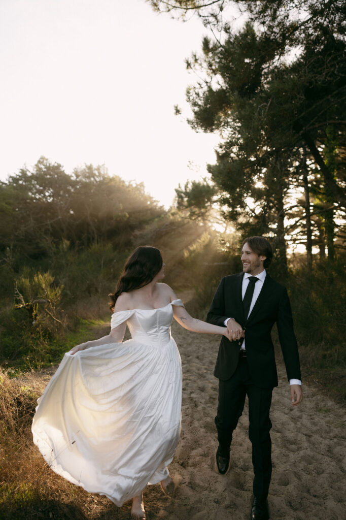 Couple walking down a sandy hill during their intimate elopement