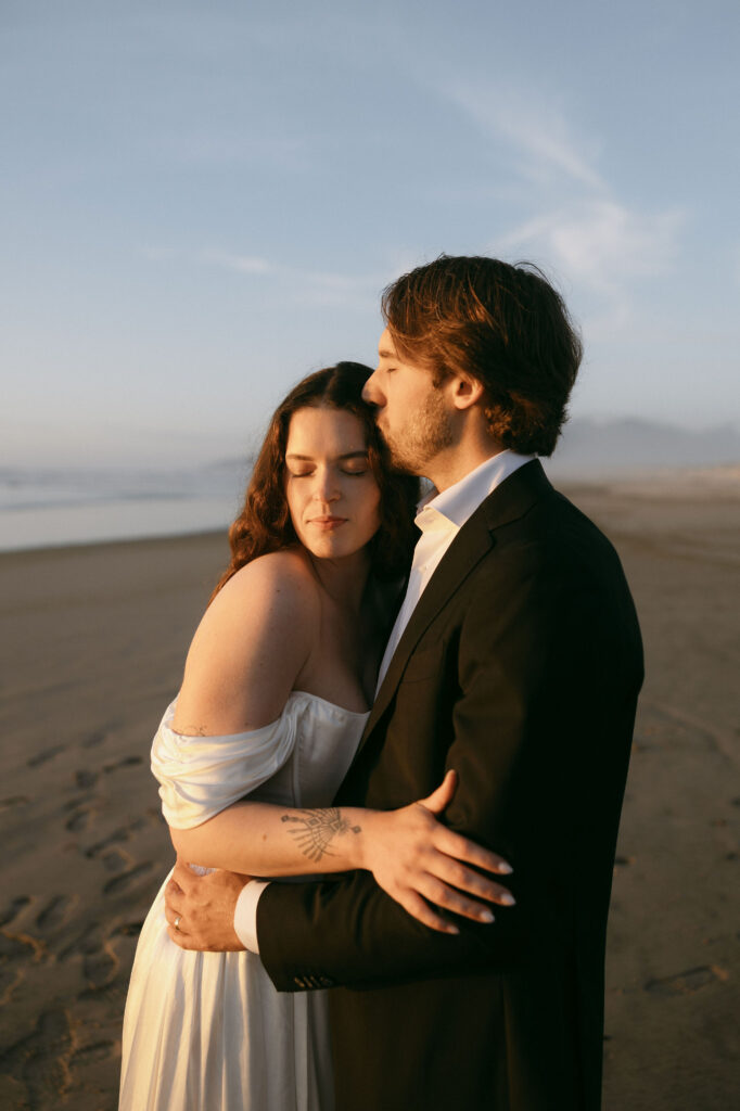 Couple posing on the beach during their Northern Oregon Coast elopement at Nehalem Bay State Park