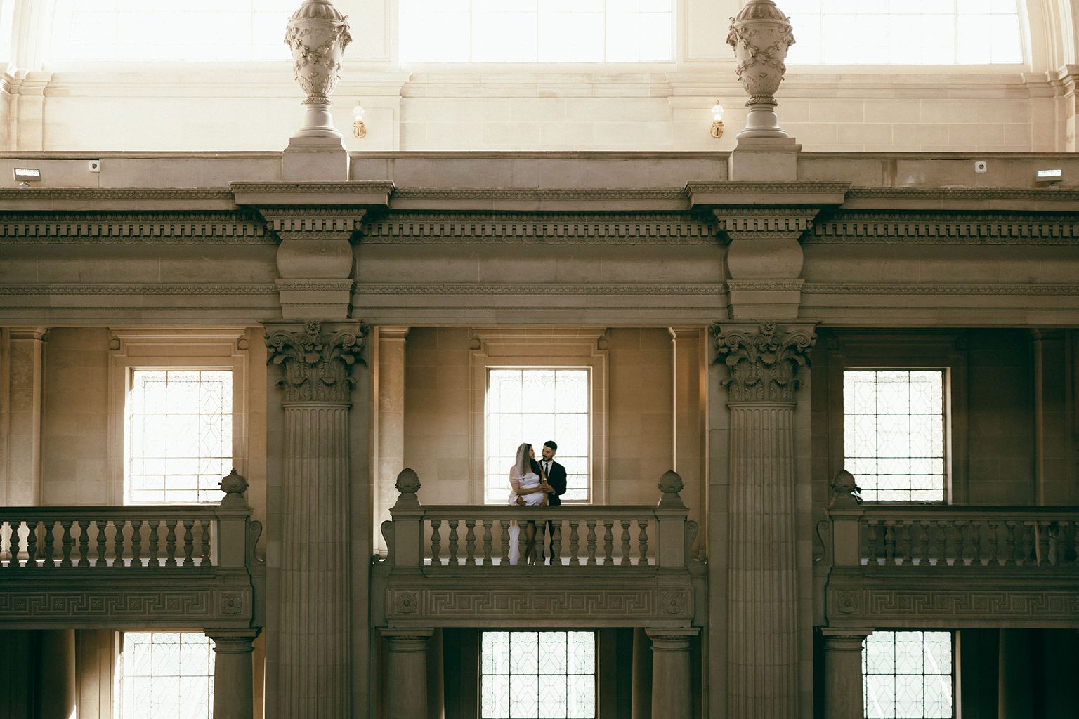 Couple posing on the balcony for their San Francisco City Hall engagement photos