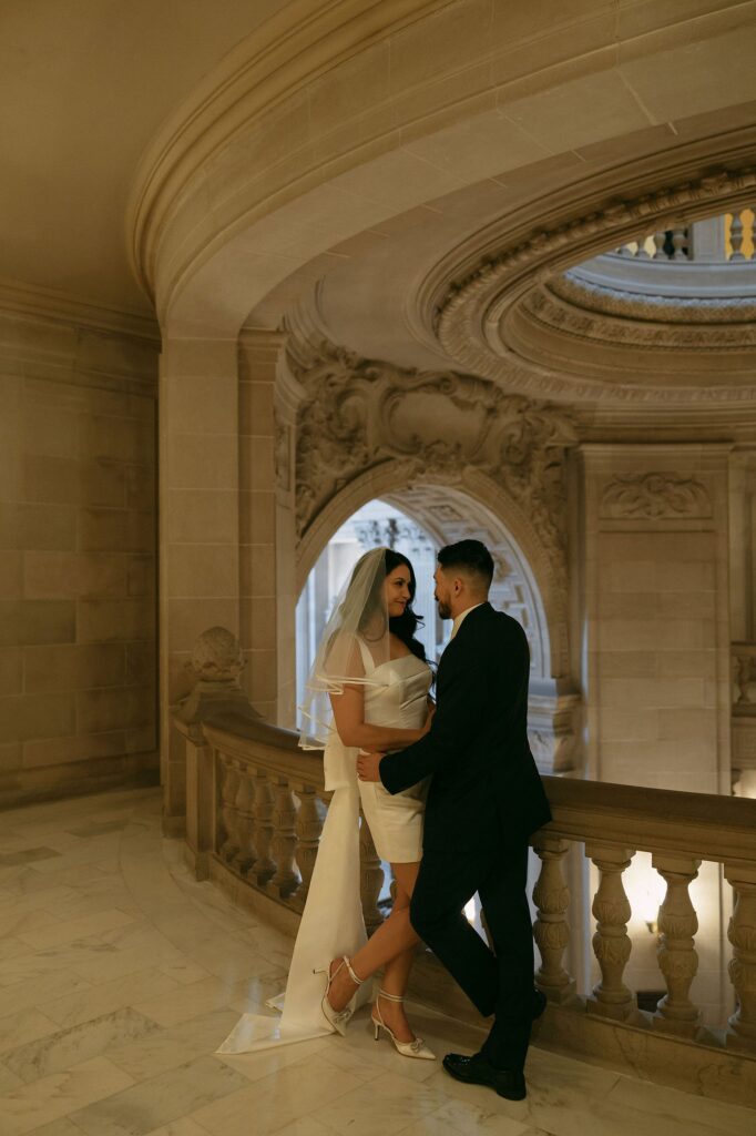 Couple posing on the balcony for their San Francisco City Hall engagement photos