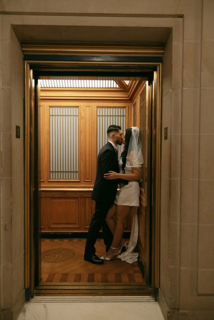 Couple kissing in the historic elevators for their San Francisco City Hall engagement photos