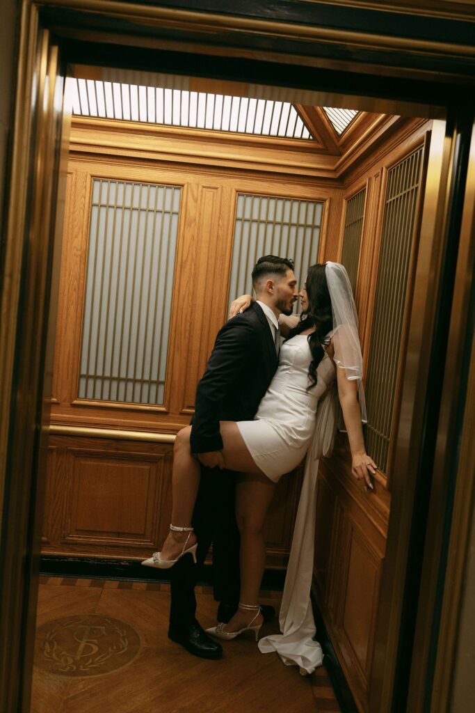 Couple posing in the historic elevators for their San Francisco City Hall engagement photos