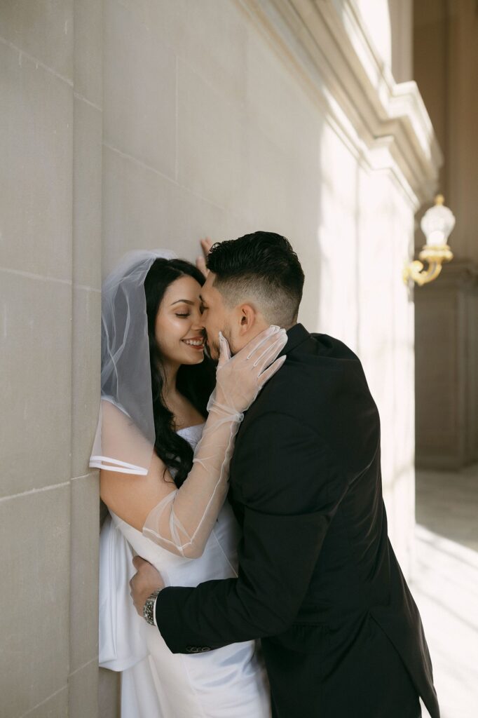 Couple going in for a kiss during their romantic SF City Hall engagement photos