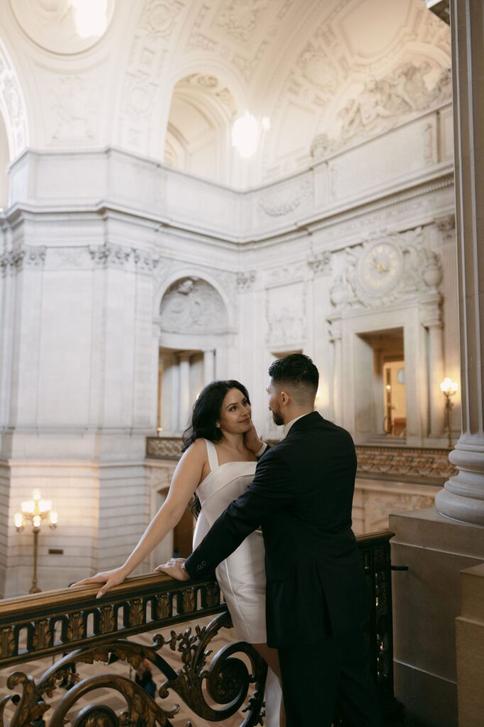 Couple leaning against the balcony at San Francisco City Hall