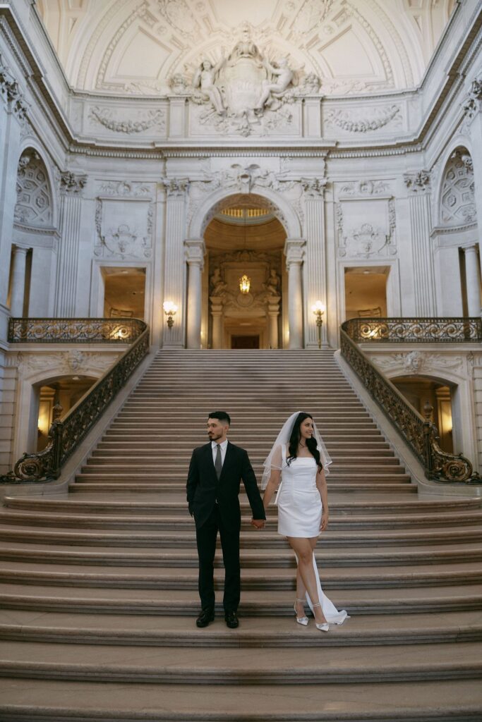 Couple posing on the grand staircase for their San Francisco engagement photos