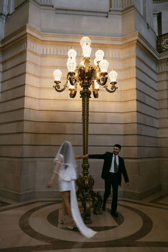 Couple twirling around the lights at the city hall