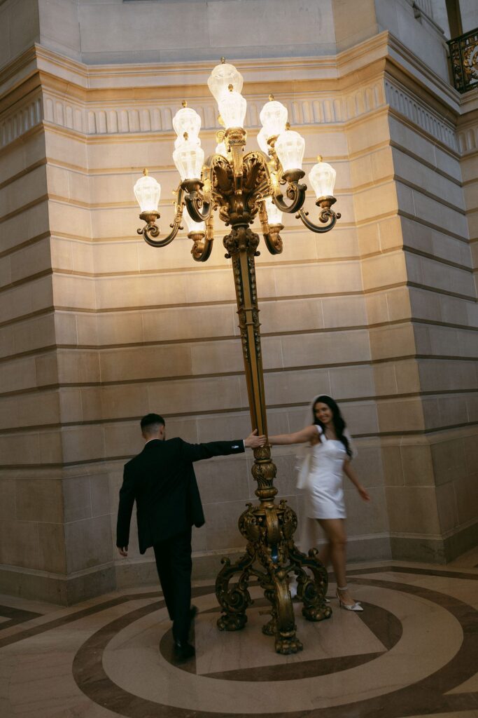 Couple twirling around the lights at the city hall