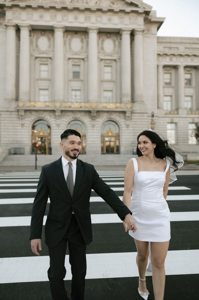 Couple holding hands and walking across the street