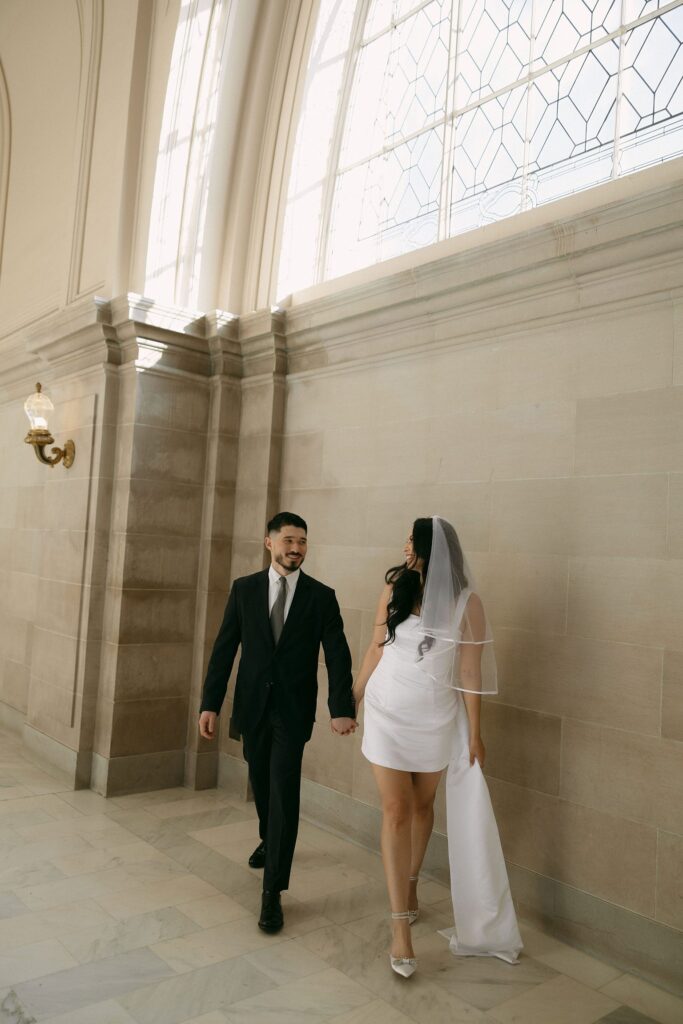 Couple holding hands and walking through city hall