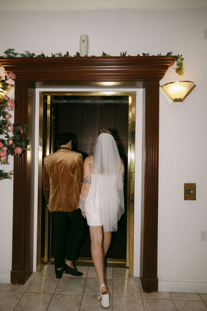 Flash photo of a bride and groom getting on the elevator at Chapel Amore