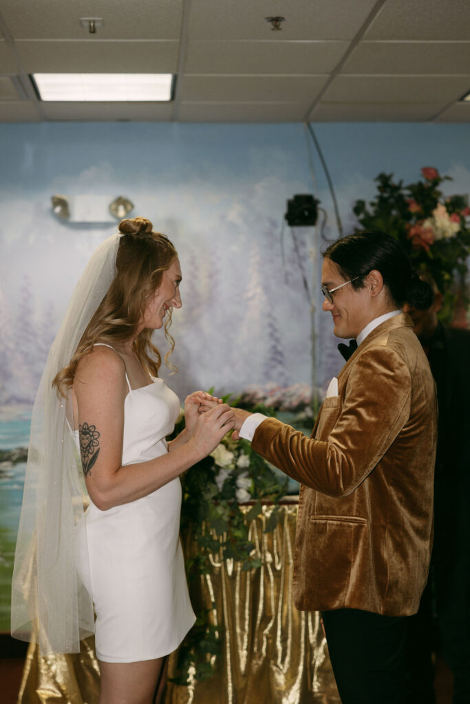 Bride and groom exchanging rings during their Las Vegas wedding ceremony at Chapel Amore