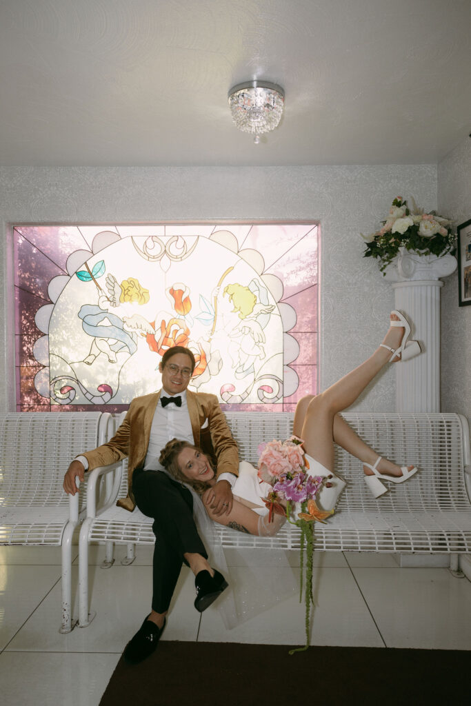 Bride and groom posing in the waiting room at Little White Wedding Chapel
