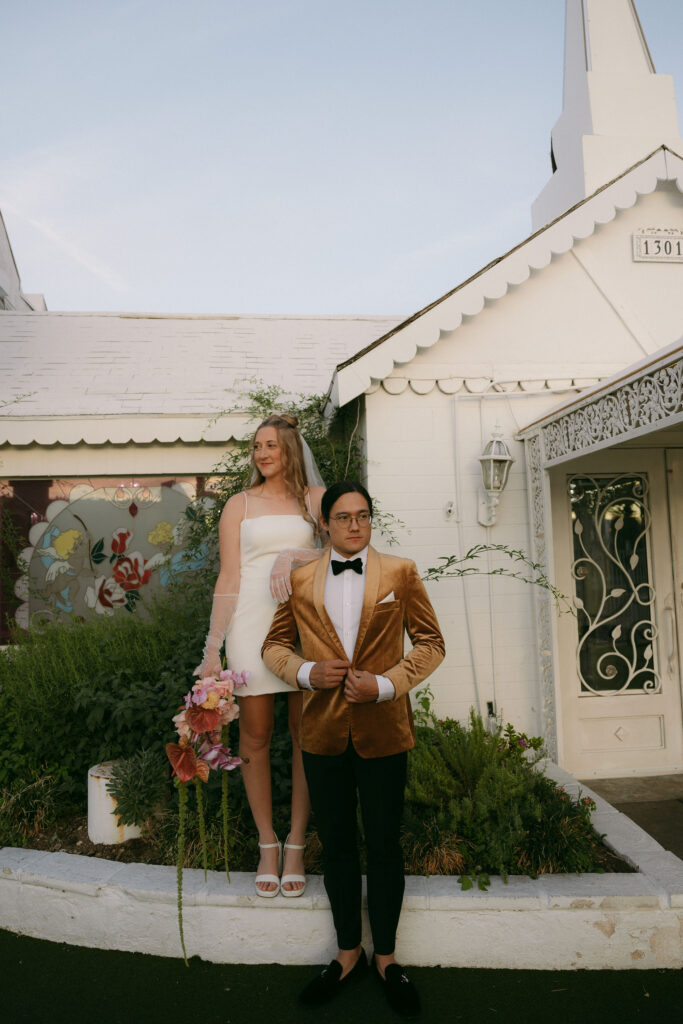 Bride and groom posing outside of The Little White Wedding Chapel