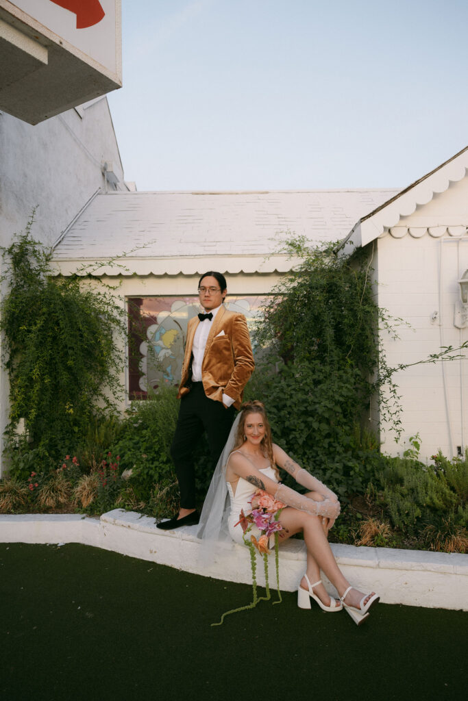 Bride and groom posing outside of The Little White Wedding Chapel
