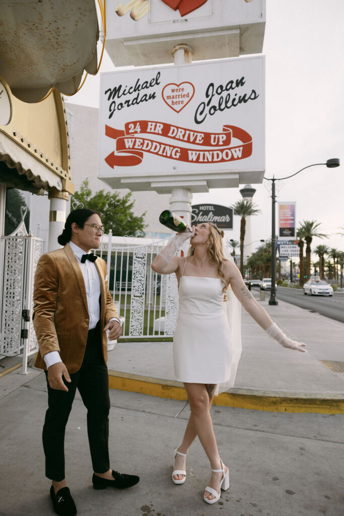 Bride drinking straight from a champagne bottle after her Little White Chapel elopement