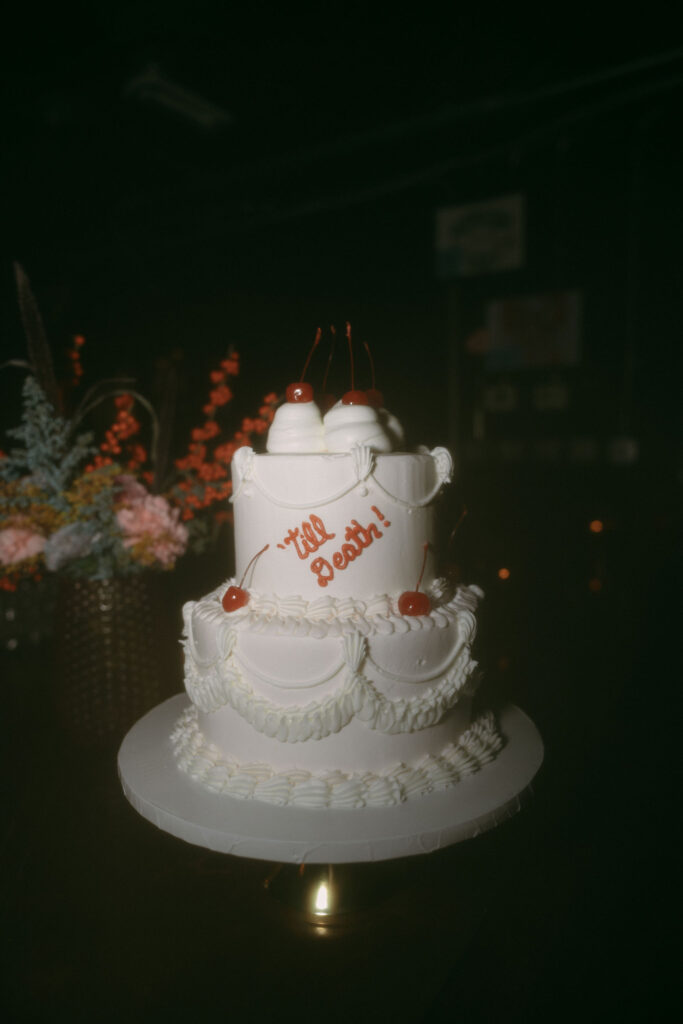 Two tiered vintage Las Vegas wedding cake that says "till death!"