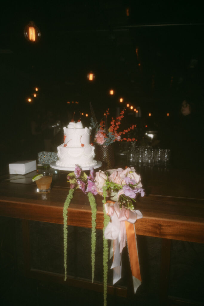 Filmy wedding reception photo of a cake and florals at Velveteen Rabbit in Las Vegas