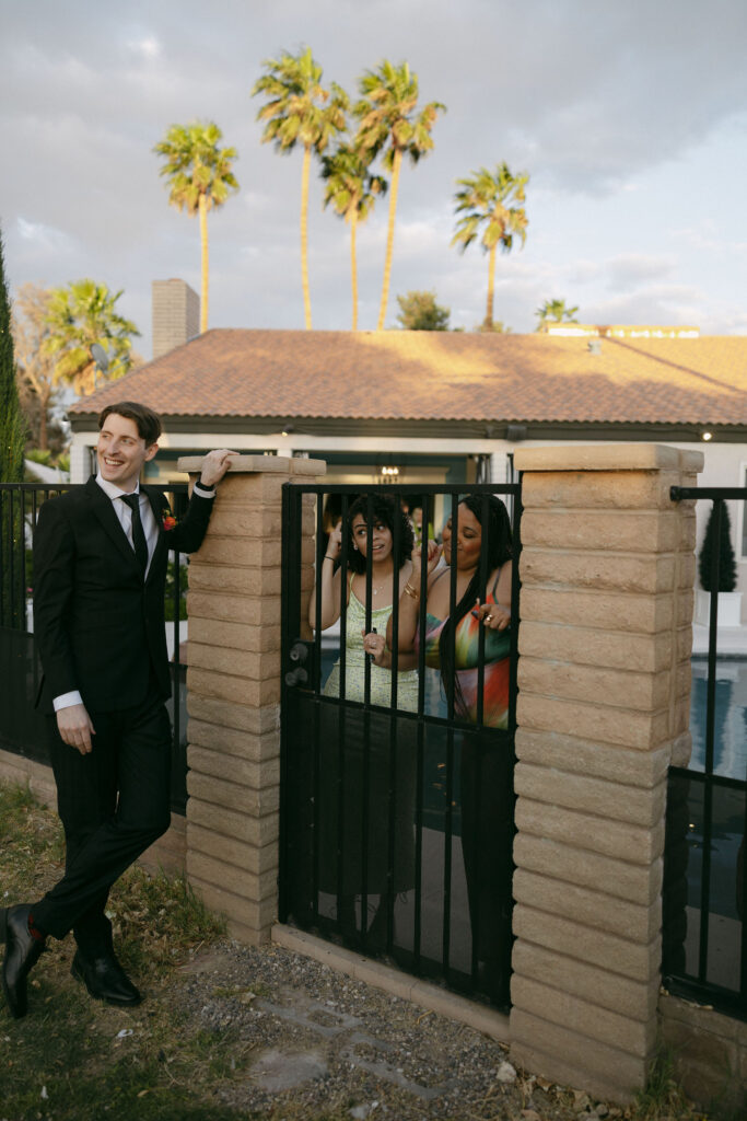 Groom and brides friends admiring her as she takes her portraits
