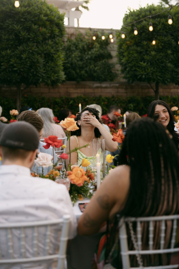 Candid wedding reception photo of guests laughing at Midcentury Manor