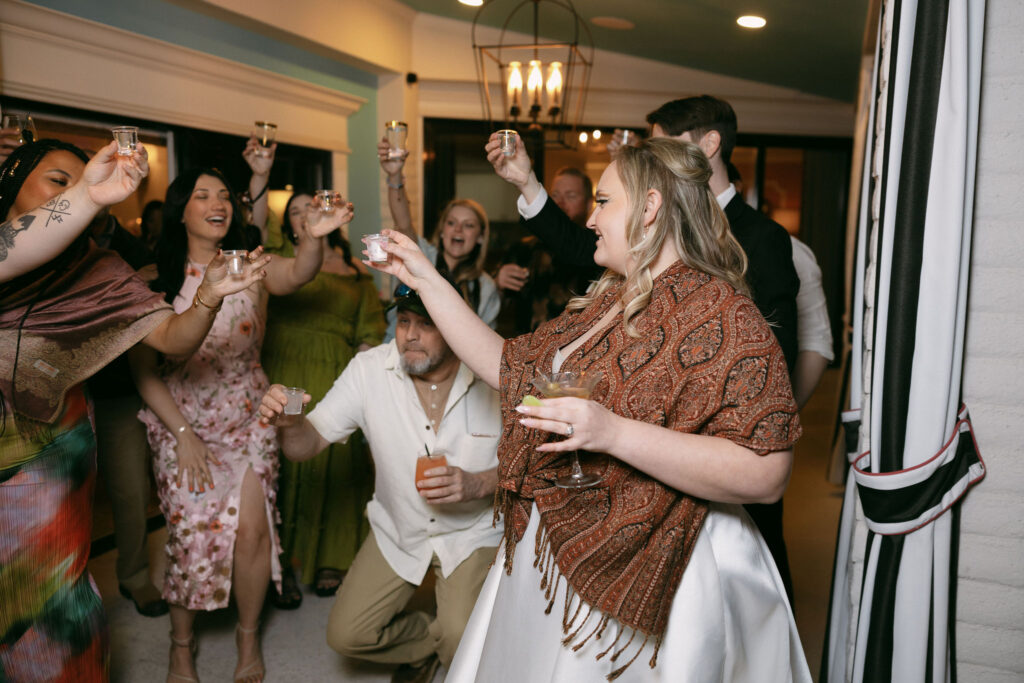 Bride taking shot with guests