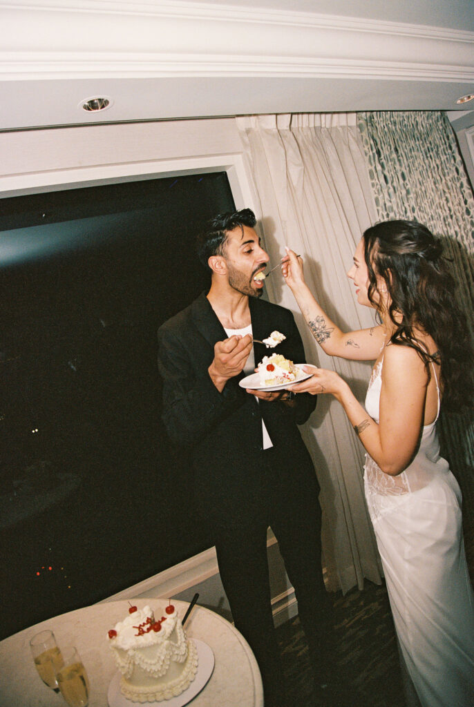 Couple feeding eachother bites from their elopement cake