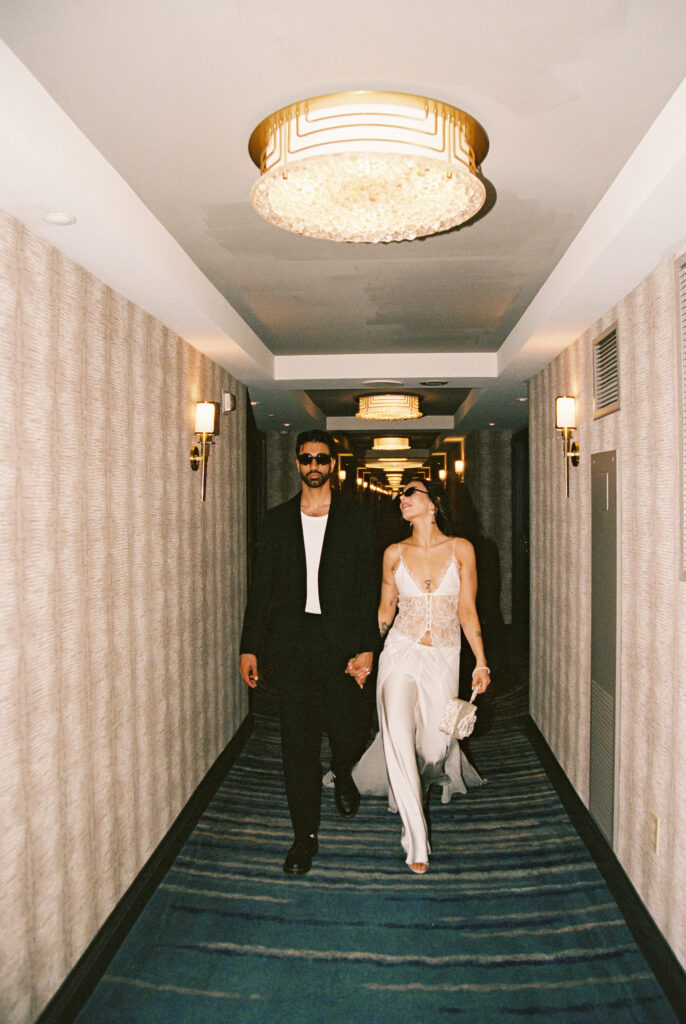 Candid photo of a couple walking down a hotel hallway