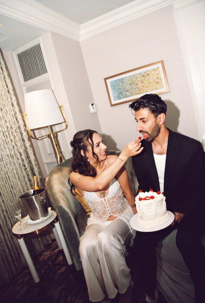 Bride feeding her groom a cherry off of their elopement cake