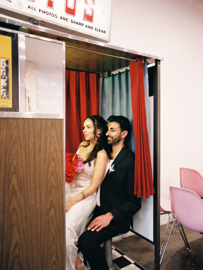 Film photo of a bride and groom posing in the vintage analog photobooth at Sure Thing Chapel