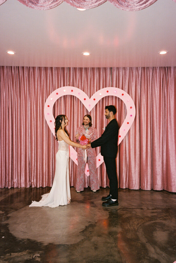 Bride and groom holding hands during their Las Vegas elopement ceremony at Sure Thing Chapel