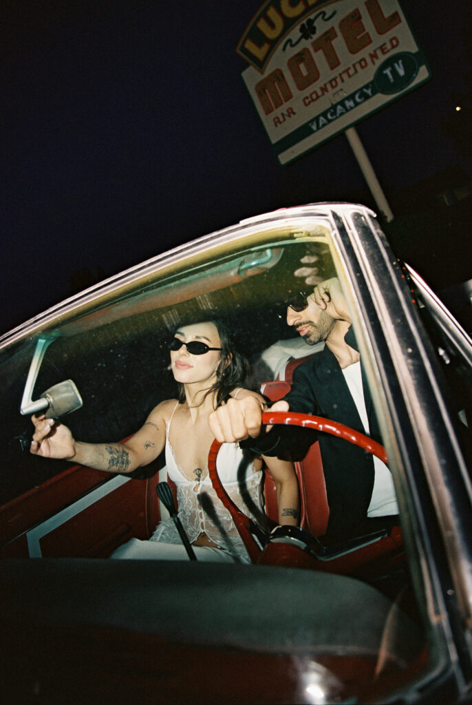 Bride and groom posing in a car for their Las Vegas elopement photos