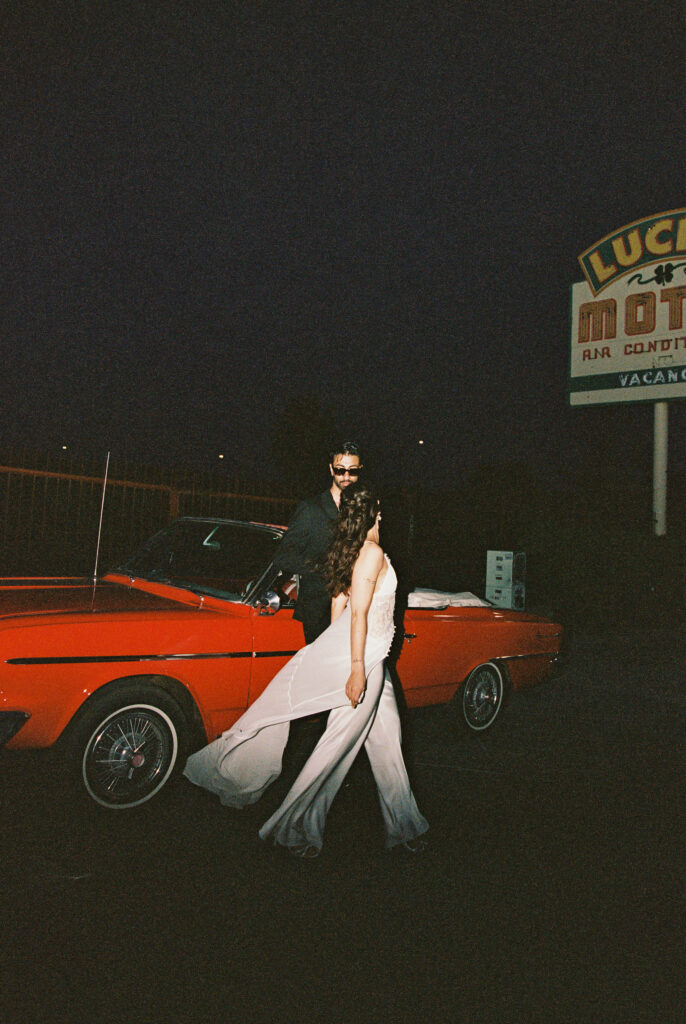 Couples film elopement photos with a red convertible in Las Vegas