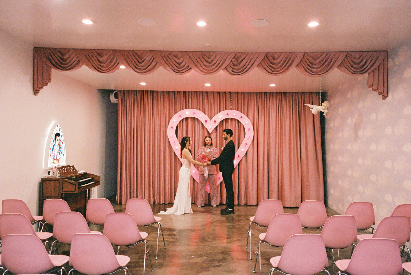 Film elopement photos of a bride and groom holding hands during their Sure Thing Chapel ceremony